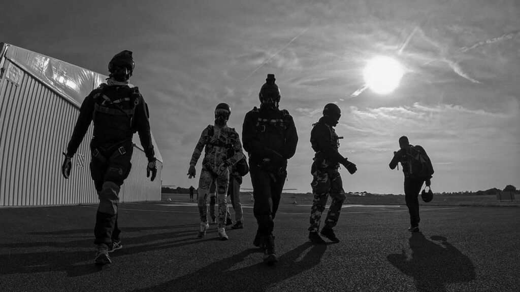 Parahutiste chez Vendée Évasion Parachutisme marchant vers l’avion, équipés pour un saut sous oxygène, soleil rasant.